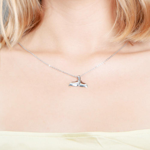 The picture shows a model wearing a 925 sterling silver whale tail pendant.